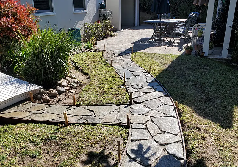Flagstone paved walkway in a backyard 
